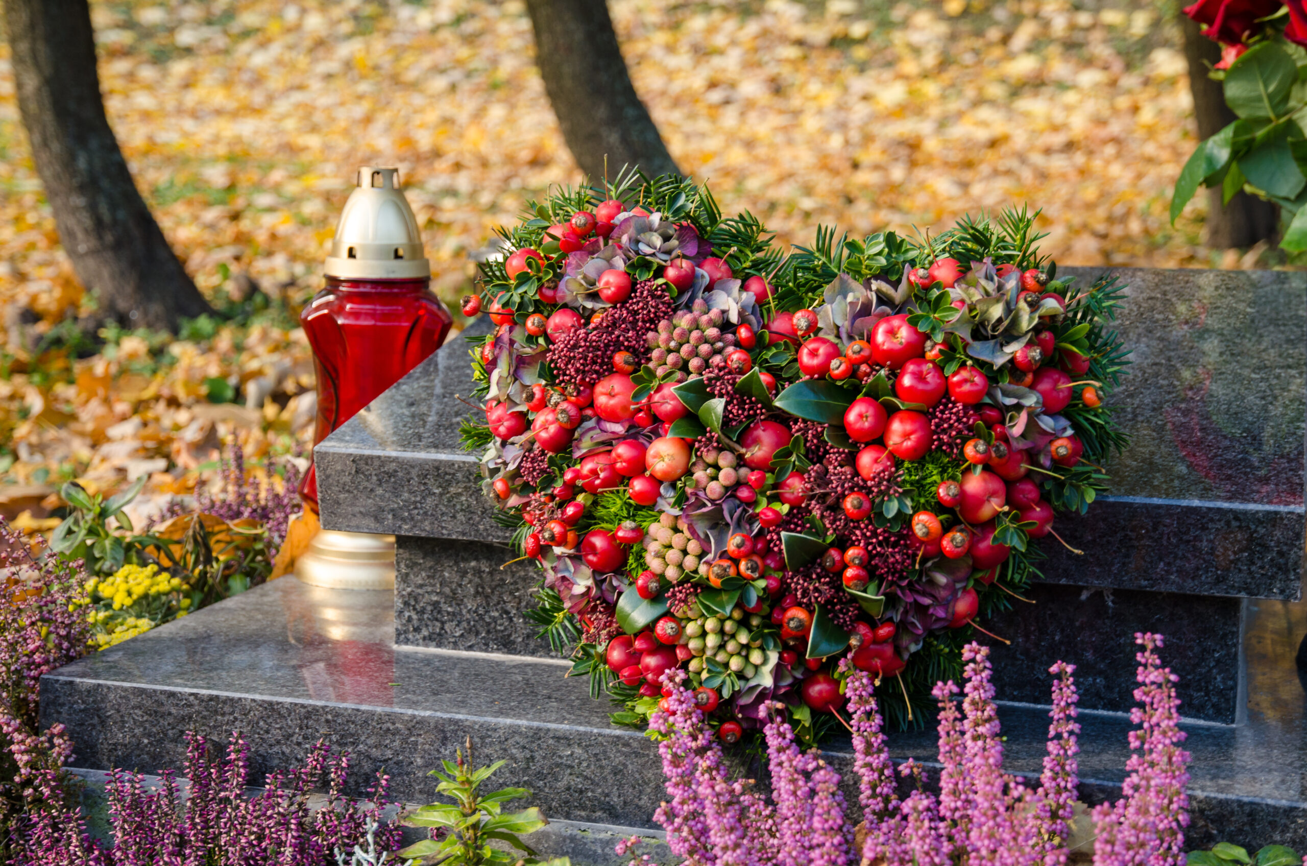 ハート型の花飾りが置かれた墓石が、定期的な清掃で美しく保たれているイメージ。高齢でも安心してお墓を管理できる様子を表現